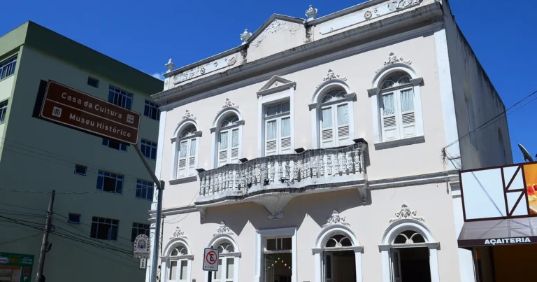 Fachada da Casa de Cultura e Museu Histórico, casarão de 1915 no centro de Domingos Martins - ES, com a placa turística marrom em primeiro plano