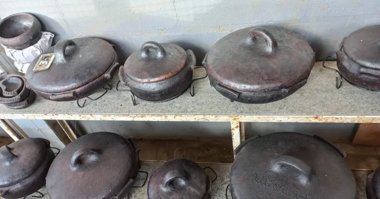 Panelas de barro de Goiabeiras prontas, com tampa, enfileiradas nas prateleiras do galpão das paneleiras