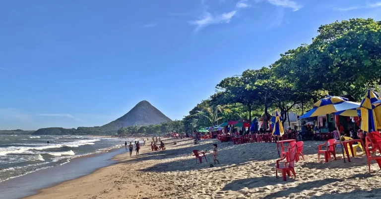 Orla de Piúma, no litoral sul do Espírito Santo, com faixa de areia, quiosques e o Monte Aghá ao fundo
