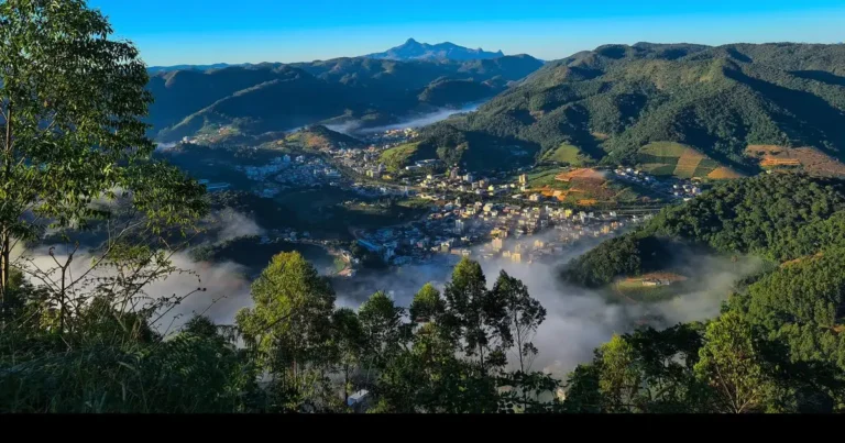 Vista aérea de Venda Nova do Imigrante - ES entre montanhas verdes, com neblina no vale e pico ao fundo