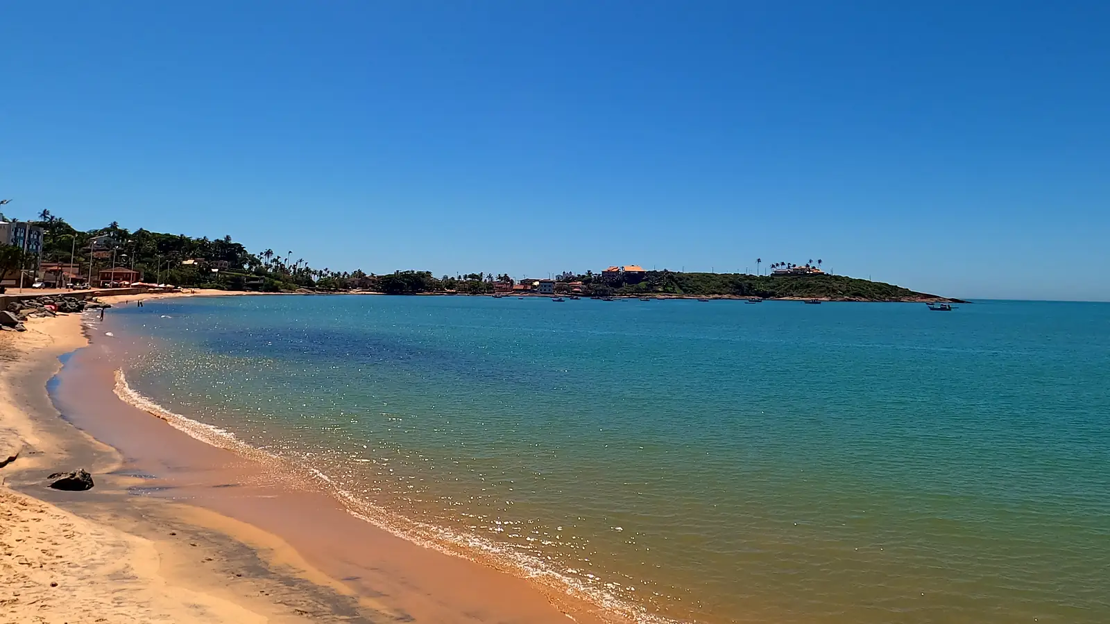 Praia de Meaípe, em Guarapari (ES), em janeiro de 2022, antes da engorda, com a faixa de areia estreita junto das pedras do calçadão e o mar calmo da enseada